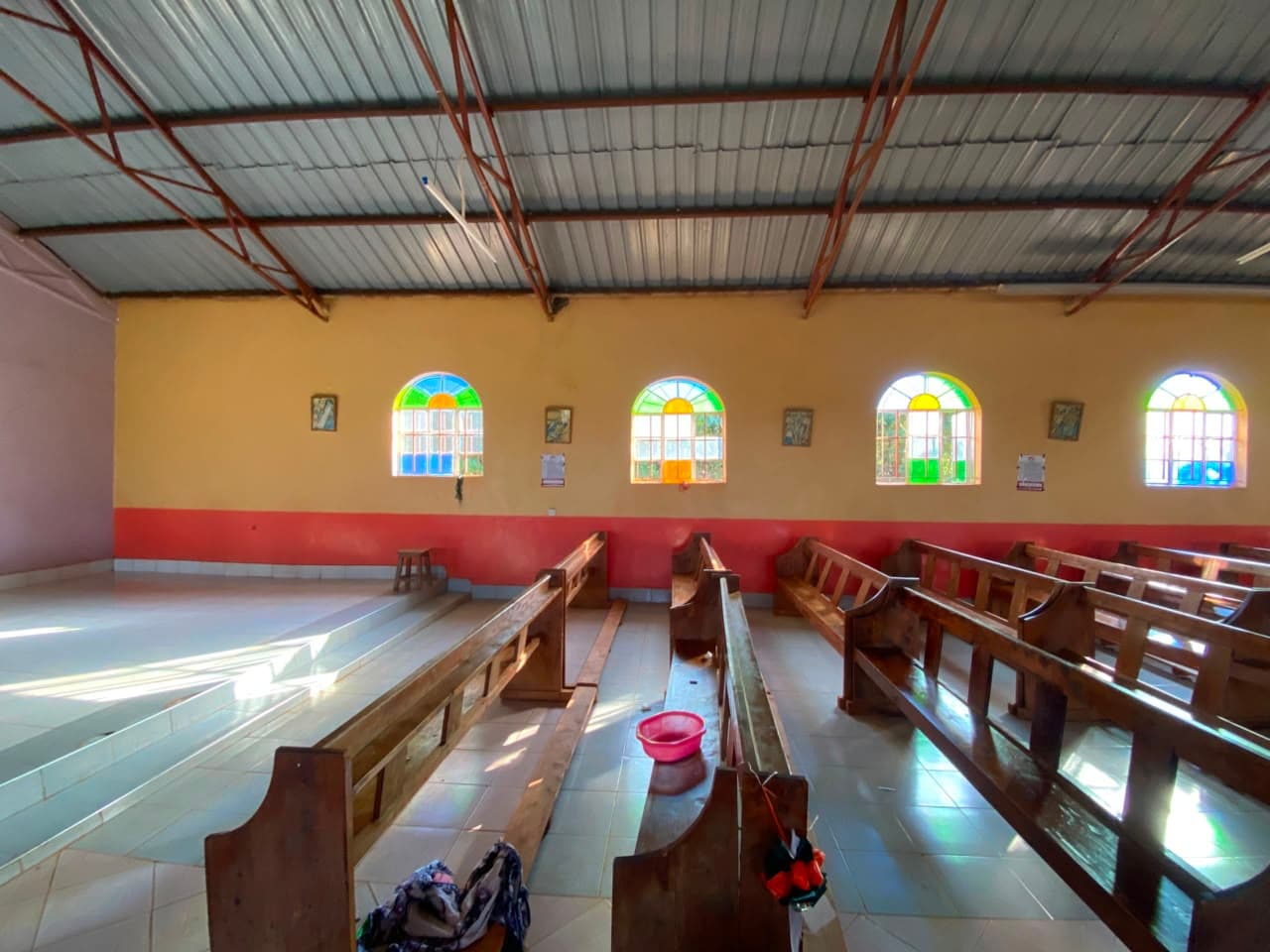 Inside the nave, a basin catches water leaking through the roof during rain.