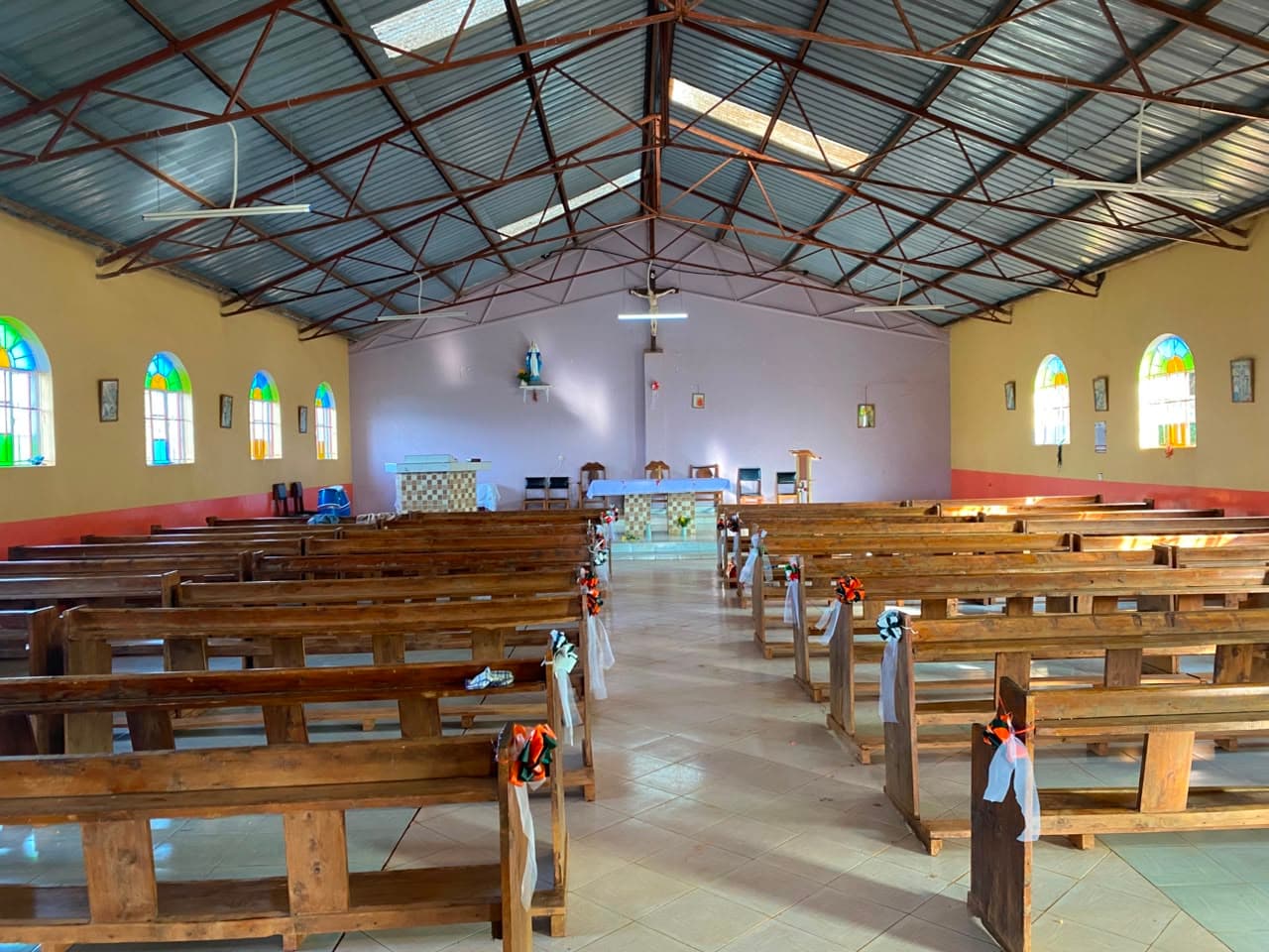 The nave decorated for a celebration, pews stretching toward the altar.